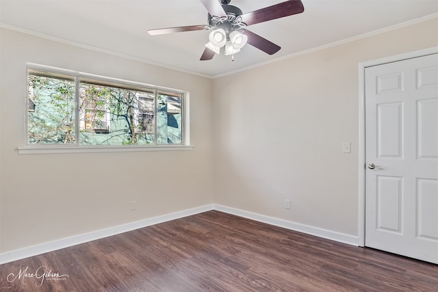 empty room featuring crown molding, dark wood-style floors, baseboards, and ceiling fan