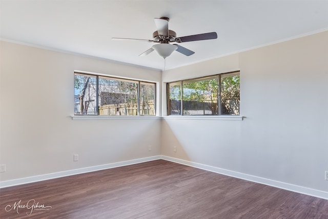 empty room featuring baseboards, wood finished floors, and ornamental molding