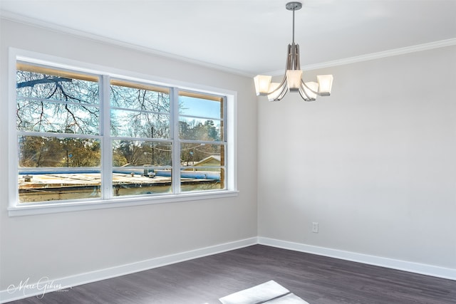 empty room with baseboards, a notable chandelier, dark wood finished floors, and crown molding