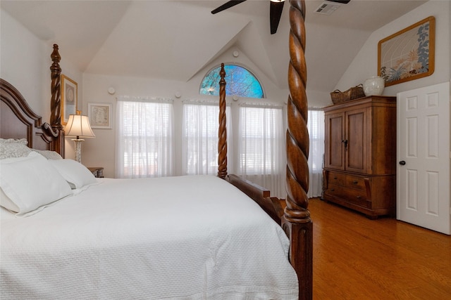 bedroom featuring vaulted ceiling, multiple windows, visible vents, and light wood-type flooring