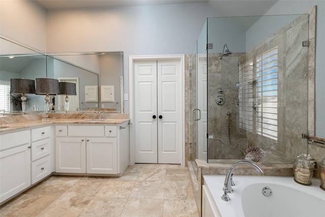 full bathroom featuring a stall shower, vanity, lofted ceiling, and a garden tub