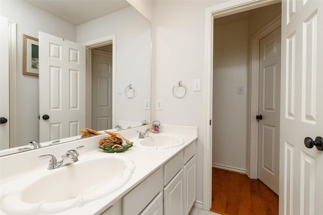 full bathroom featuring double vanity, wood finished floors, and a sink