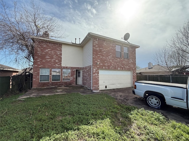 rear view of property with brick siding, fence, a lawn, a garage, and a patio