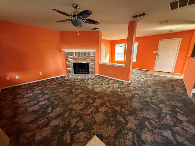 unfurnished living room with a brick fireplace, visible vents, and carpet floors