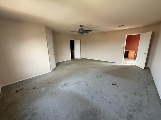 unfurnished room with visible vents, carpet floors, baseboards, and ceiling fan