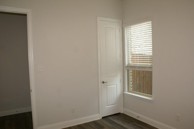 unfurnished bedroom featuring dark wood finished floors and baseboards