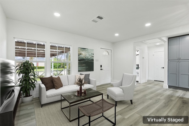 living area featuring visible vents, recessed lighting, and light wood-style floors