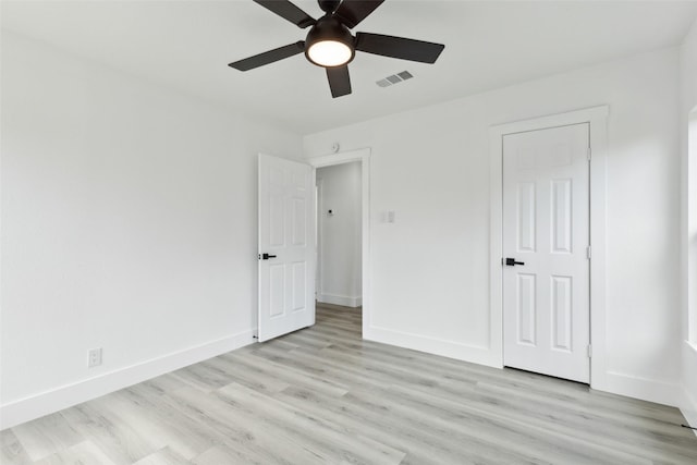 unfurnished bedroom featuring ceiling fan, visible vents, baseboards, and light wood-style flooring