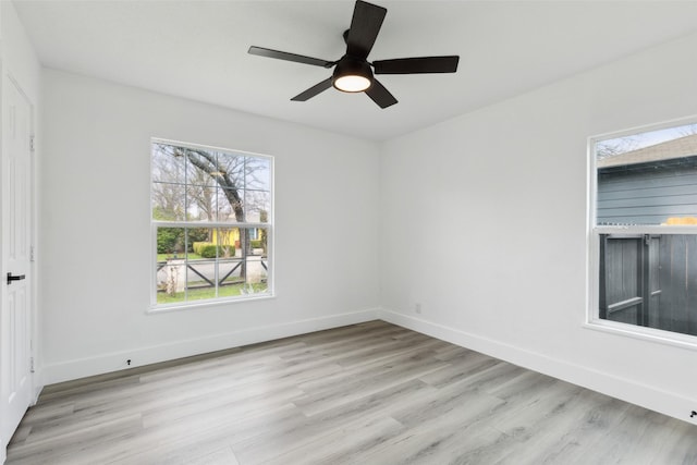 spare room featuring light wood-style floors, baseboards, and ceiling fan