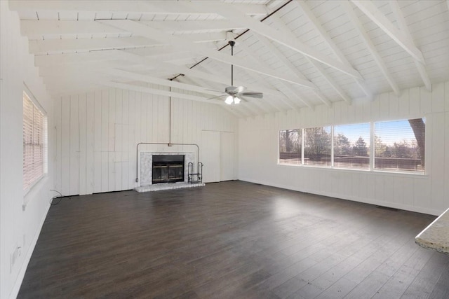 unfurnished living room with visible vents, dark wood-type flooring, a glass covered fireplace, and vaulted ceiling with beams