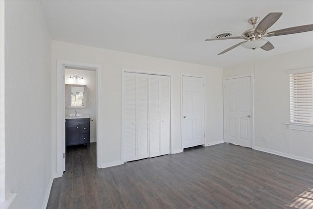 unfurnished bedroom with dark wood-style floors, baseboards, and a sink