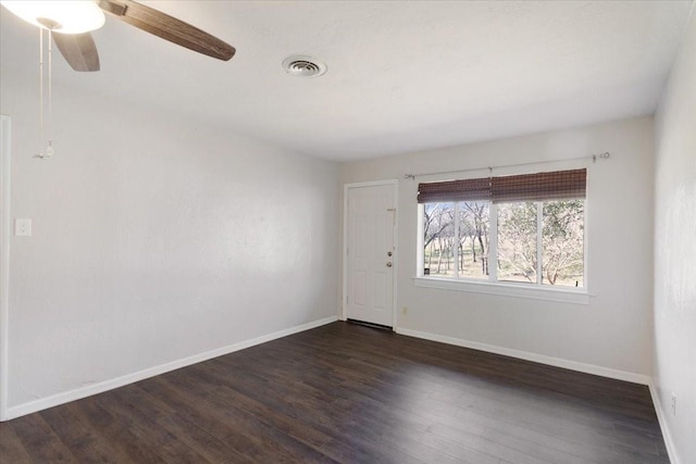 empty room with visible vents, ceiling fan, baseboards, and wood finished floors