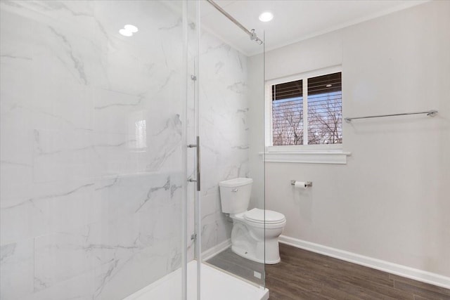 bathroom with a marble finish shower, toilet, and wood finished floors