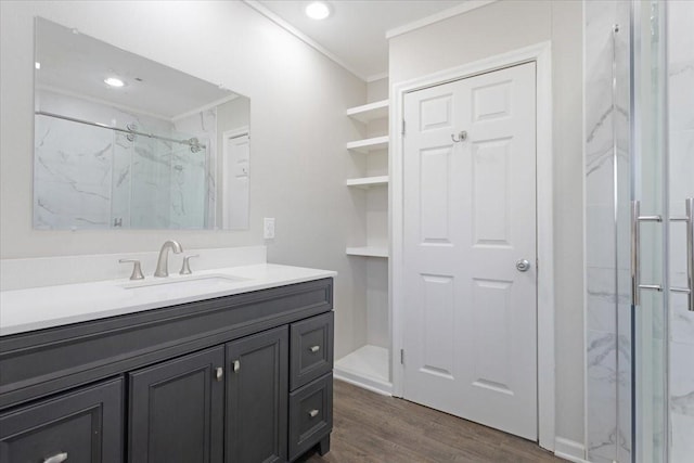 bathroom with a marble finish shower, ornamental molding, recessed lighting, wood finished floors, and vanity