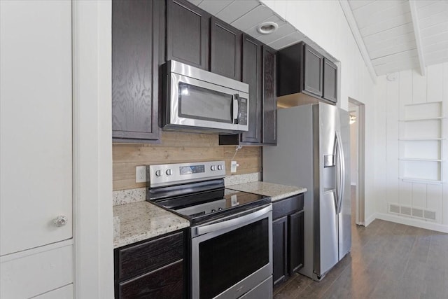 kitchen with visible vents, backsplash, light stone countertops, appliances with stainless steel finishes, and dark wood-style floors