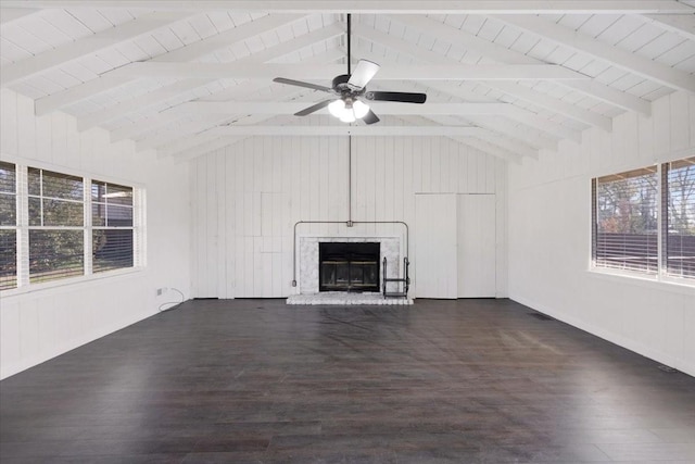 unfurnished living room featuring a glass covered fireplace, vaulted ceiling with beams, and dark wood-type flooring