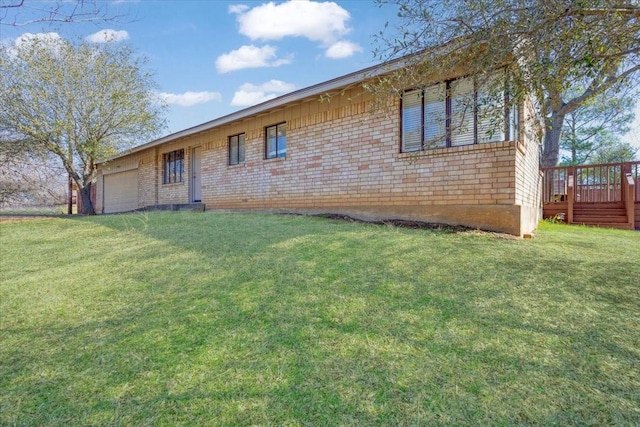 view of front of property featuring brick siding, a garage, a wooden deck, and a front lawn