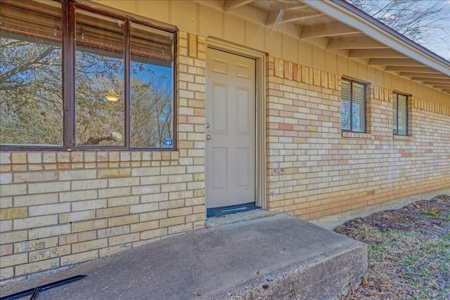 entrance to property featuring brick siding