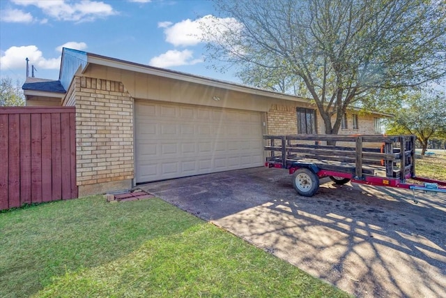 garage featuring driveway and fence