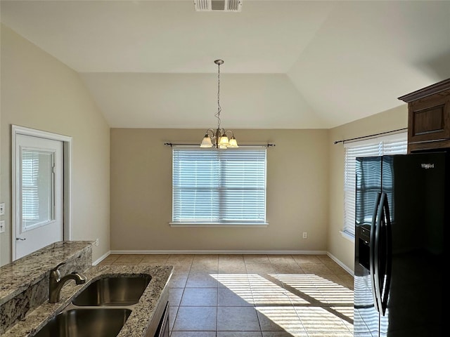 kitchen with hanging light fixtures, vaulted ceiling, black fridge with ice dispenser, and a sink