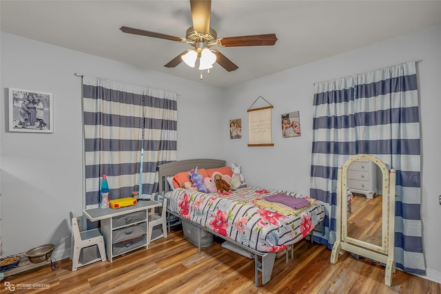 bedroom with baseboards, wood finished floors, and a ceiling fan