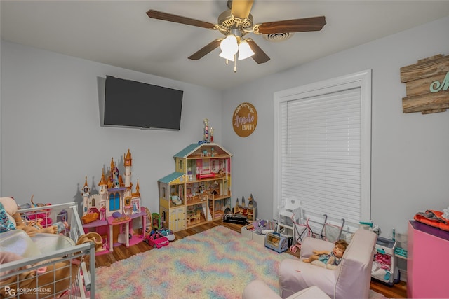 playroom with a ceiling fan and wood finished floors