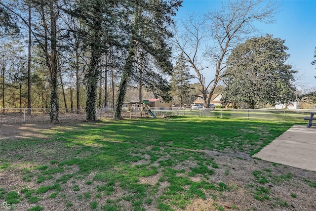 view of yard featuring a fenced backyard and playground community