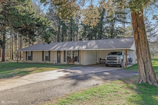 ranch-style home with aphalt driveway, brick siding, a front yard, and a carport