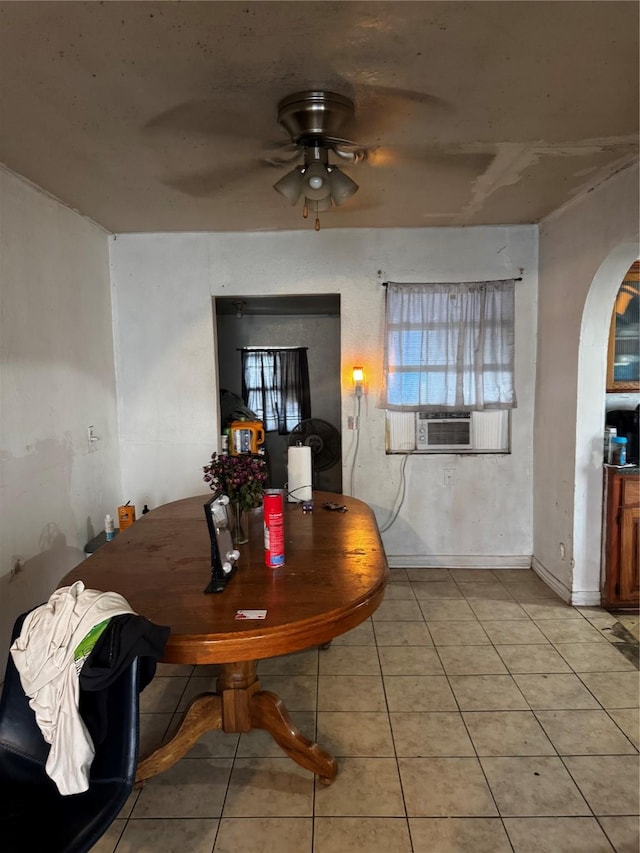 dining area with light tile patterned floors, cooling unit, arched walkways, and a ceiling fan