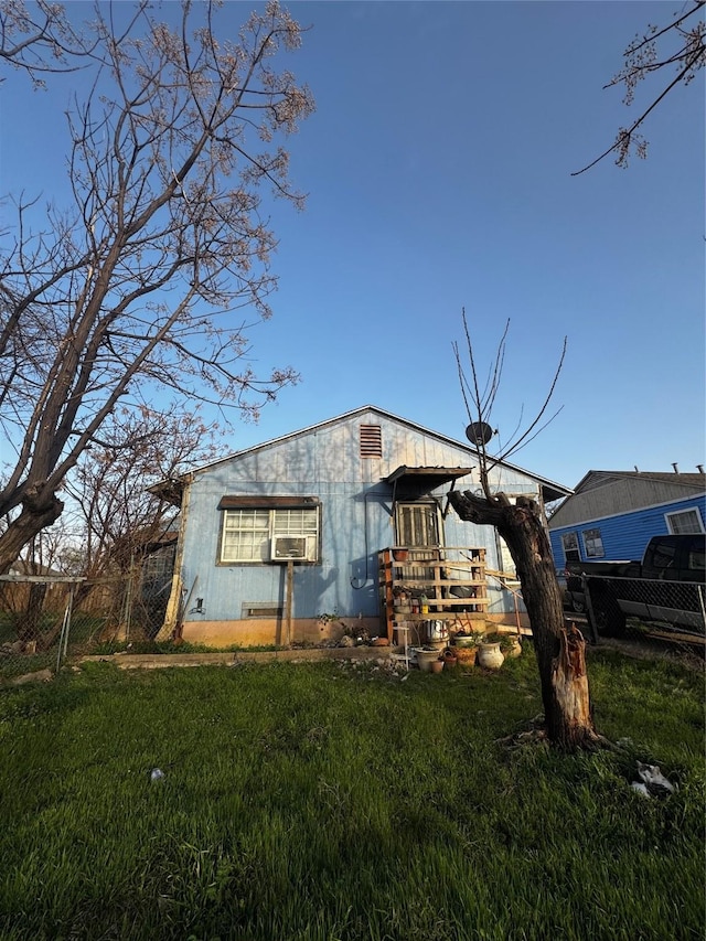 view of side of home with a yard and fence