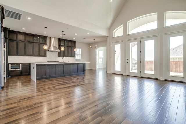 kitchen with visible vents, light countertops, appliances with stainless steel finishes, dark wood-style floors, and wall chimney exhaust hood