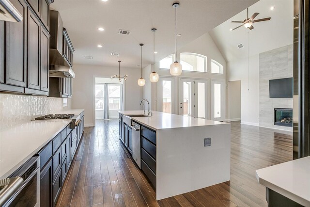 kitchen featuring visible vents, a tile fireplace, built in refrigerator, and exhaust hood