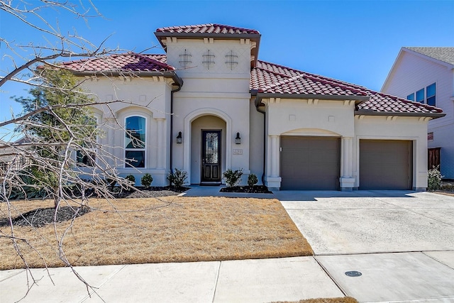 mediterranean / spanish home with a tiled roof, stucco siding, an attached garage, and driveway