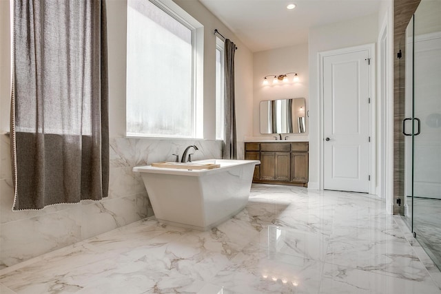 full bath with marble finish floor, recessed lighting, a shower stall, a soaking tub, and vanity