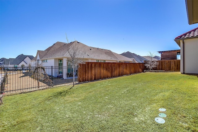 view of yard featuring a residential view and a fenced backyard