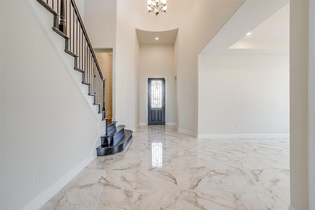 entrance foyer with stairway, baseboards, marble finish floor, and a towering ceiling