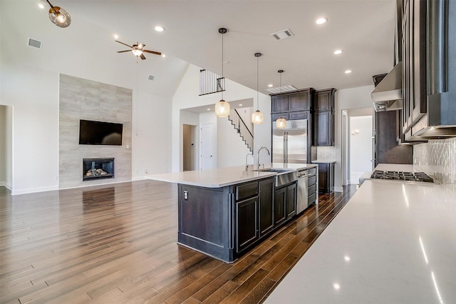 kitchen featuring ventilation hood, stainless steel built in fridge, visible vents, and a fireplace