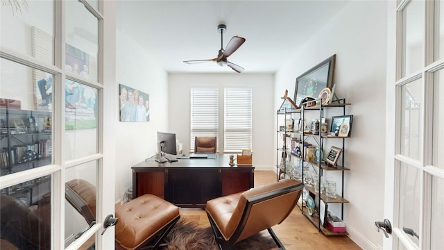 office space featuring french doors, baseboards, light wood-style flooring, and a ceiling fan