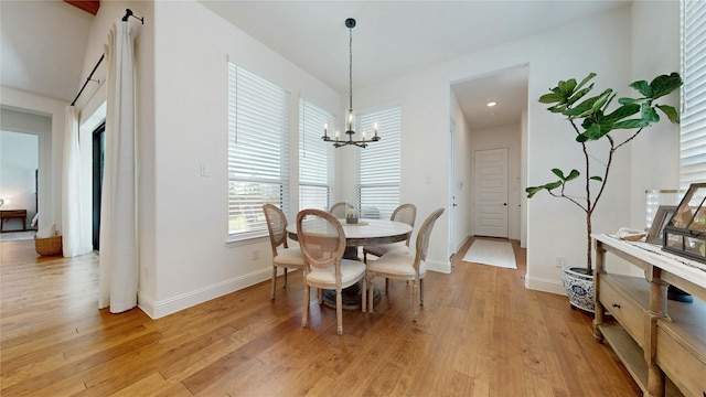 dining room with a notable chandelier, light wood-style floors, and baseboards