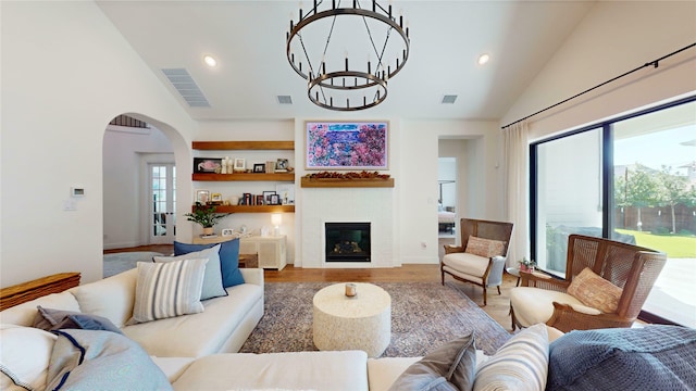 living area with arched walkways, visible vents, and wood finished floors