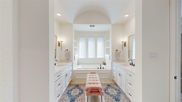 bathroom featuring visible vents, two vanities, and a sink