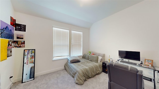 bedroom with lofted ceiling, multiple windows, light colored carpet, and baseboards