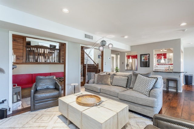 living area featuring hardwood / wood-style flooring, stairway, recessed lighting, and visible vents