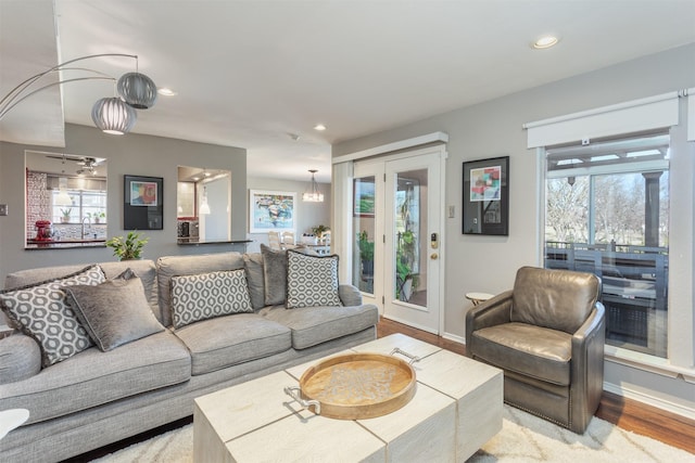 living room featuring recessed lighting, baseboards, plenty of natural light, and wood finished floors