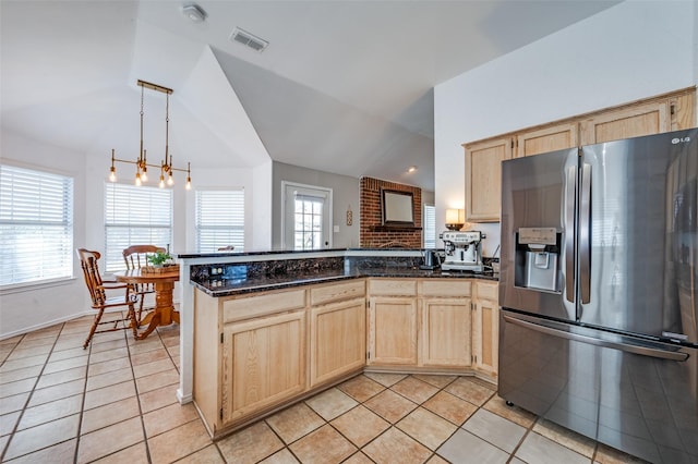 kitchen with visible vents, a peninsula, light brown cabinetry, vaulted ceiling, and stainless steel fridge