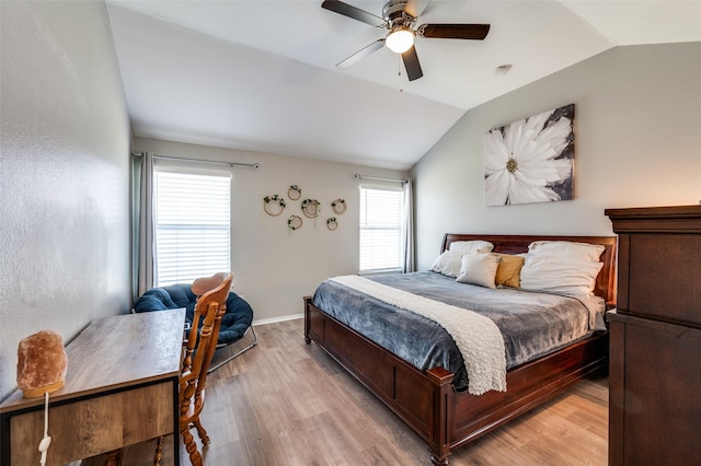 bedroom with light wood-style flooring, baseboards, a ceiling fan, and vaulted ceiling