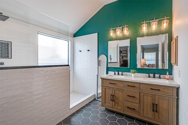 full bathroom featuring double vanity, a walk in shower, and a sink