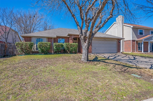 view of front of property featuring brick siding, a front lawn, fence, driveway, and an attached garage