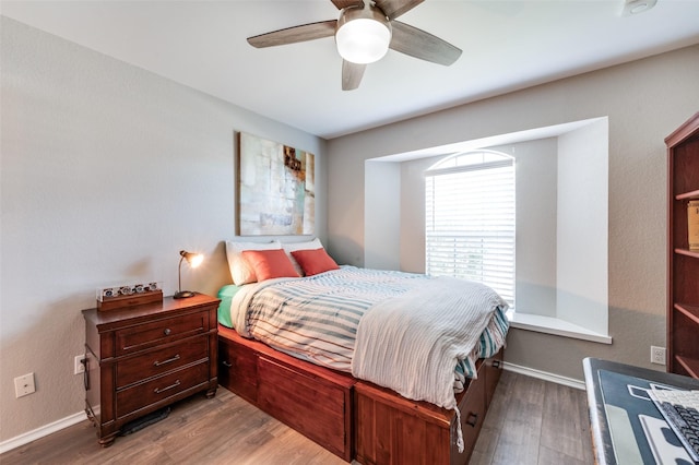 bedroom with ceiling fan, baseboards, and wood finished floors