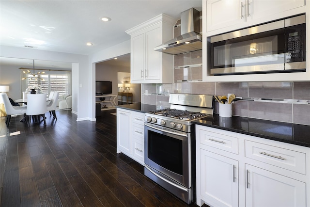 kitchen with dark wood-type flooring, wall chimney range hood, tasteful backsplash, and stainless steel appliances